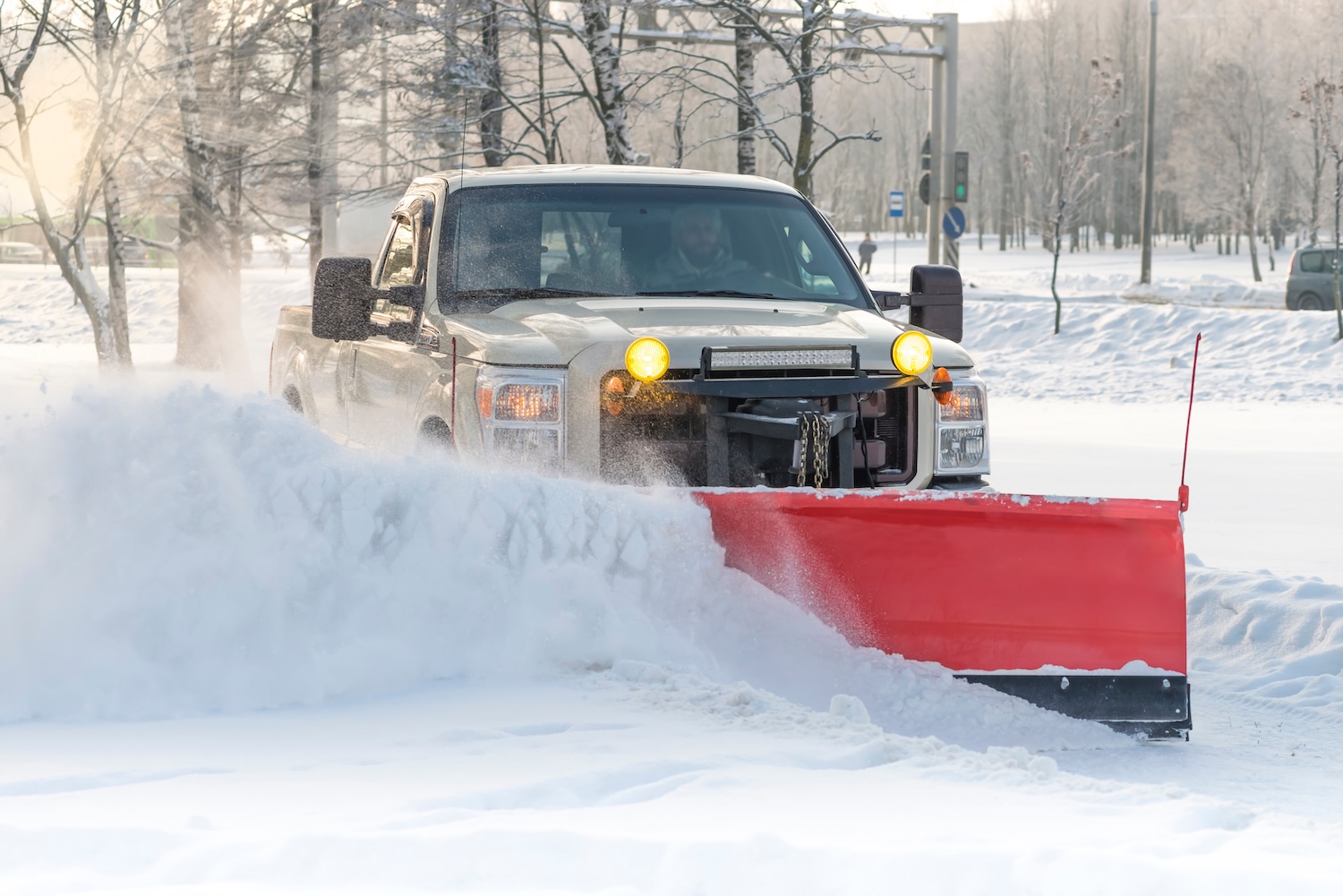 Plow truck clearing a commercial drive lane after heavy snowfall